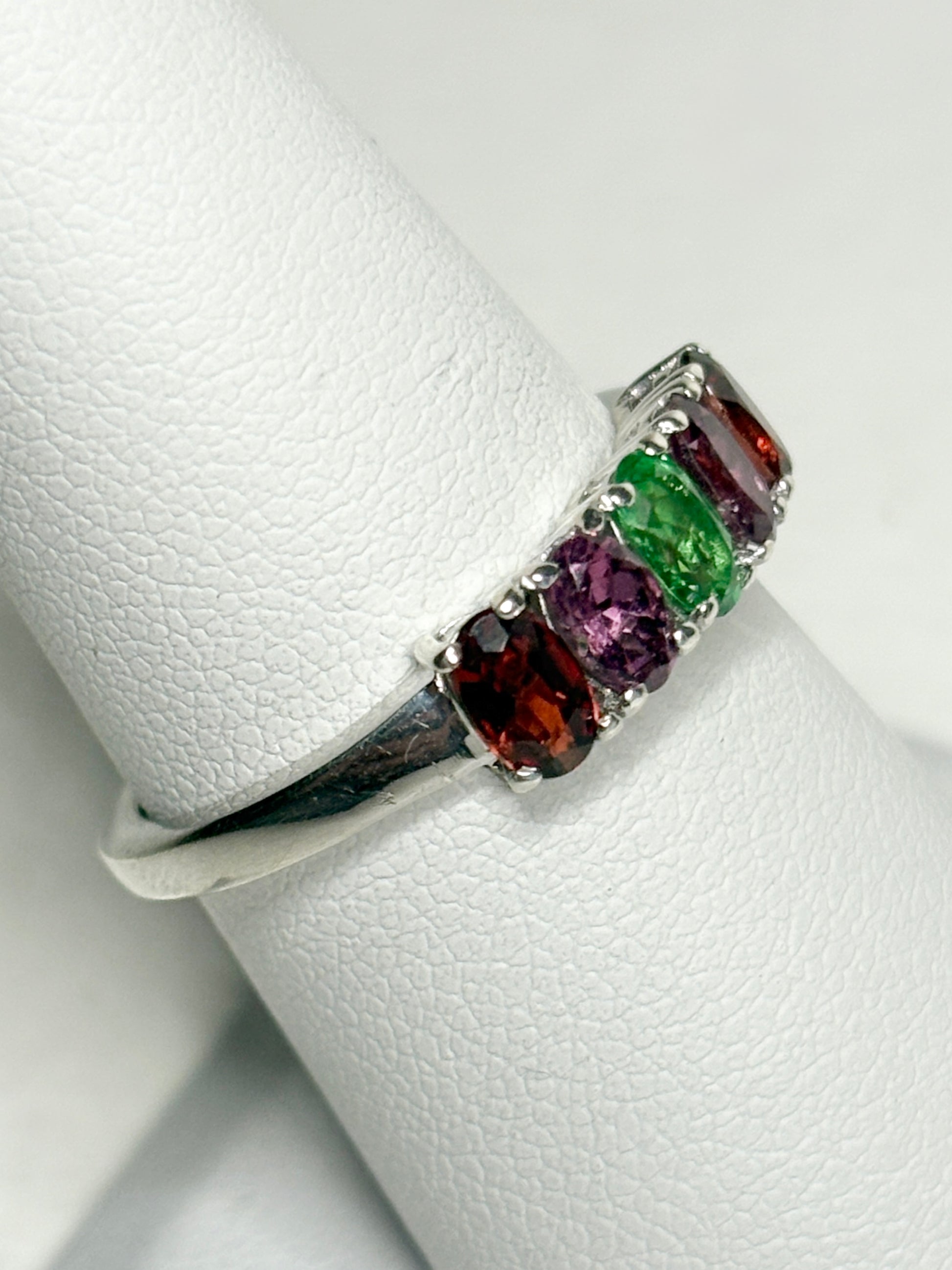 Sterling silver ring with five oval garnets in shades of red, purple, and green.
