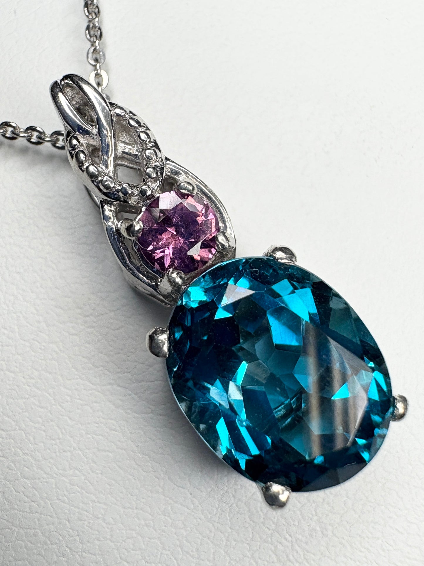 Sterling silver pendant necklace with oval London blue topaz and round rhodolite garnet.