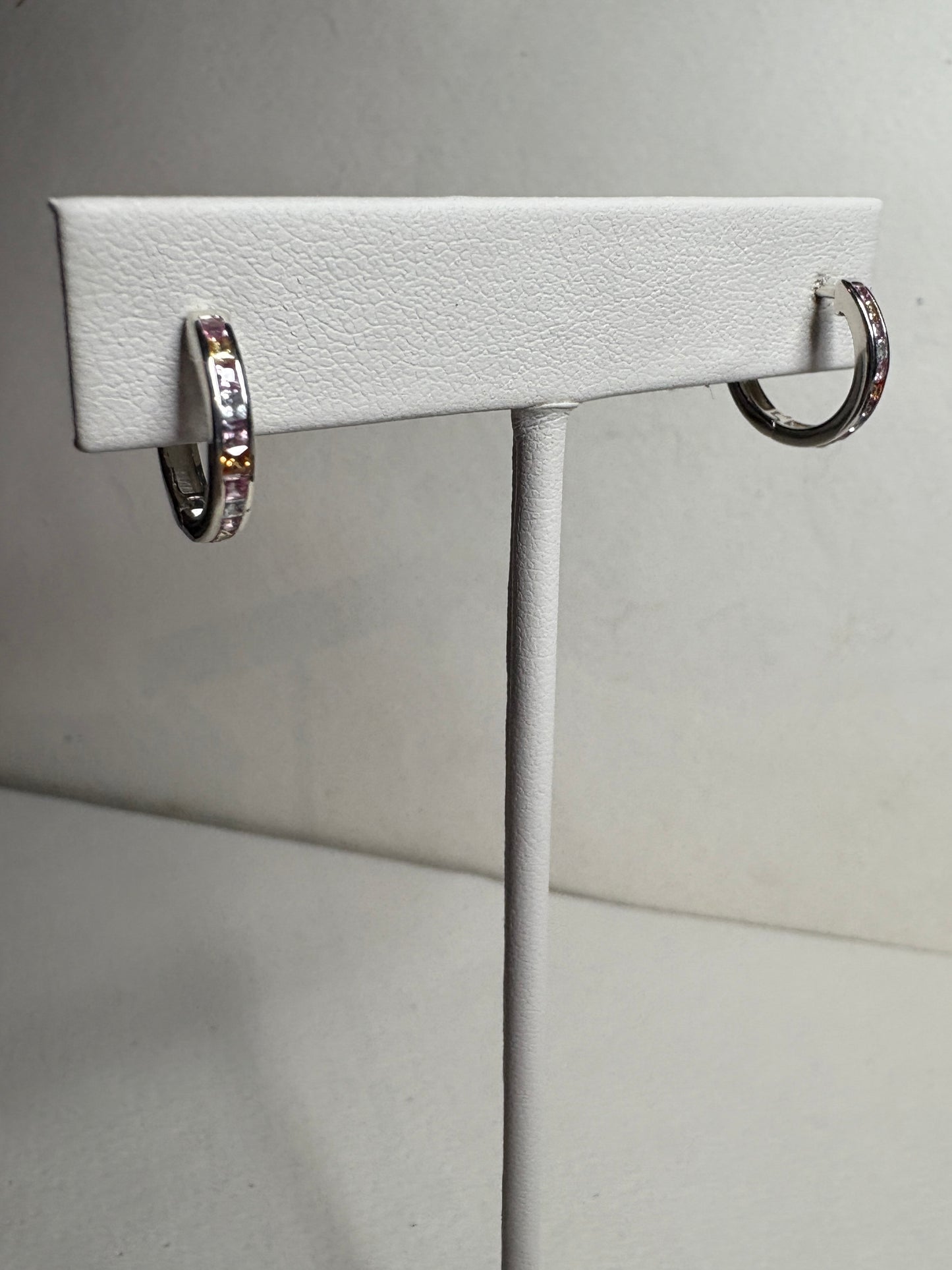 Sterling silver huggie hoop earrings with princess-cut multi-color sapphires.