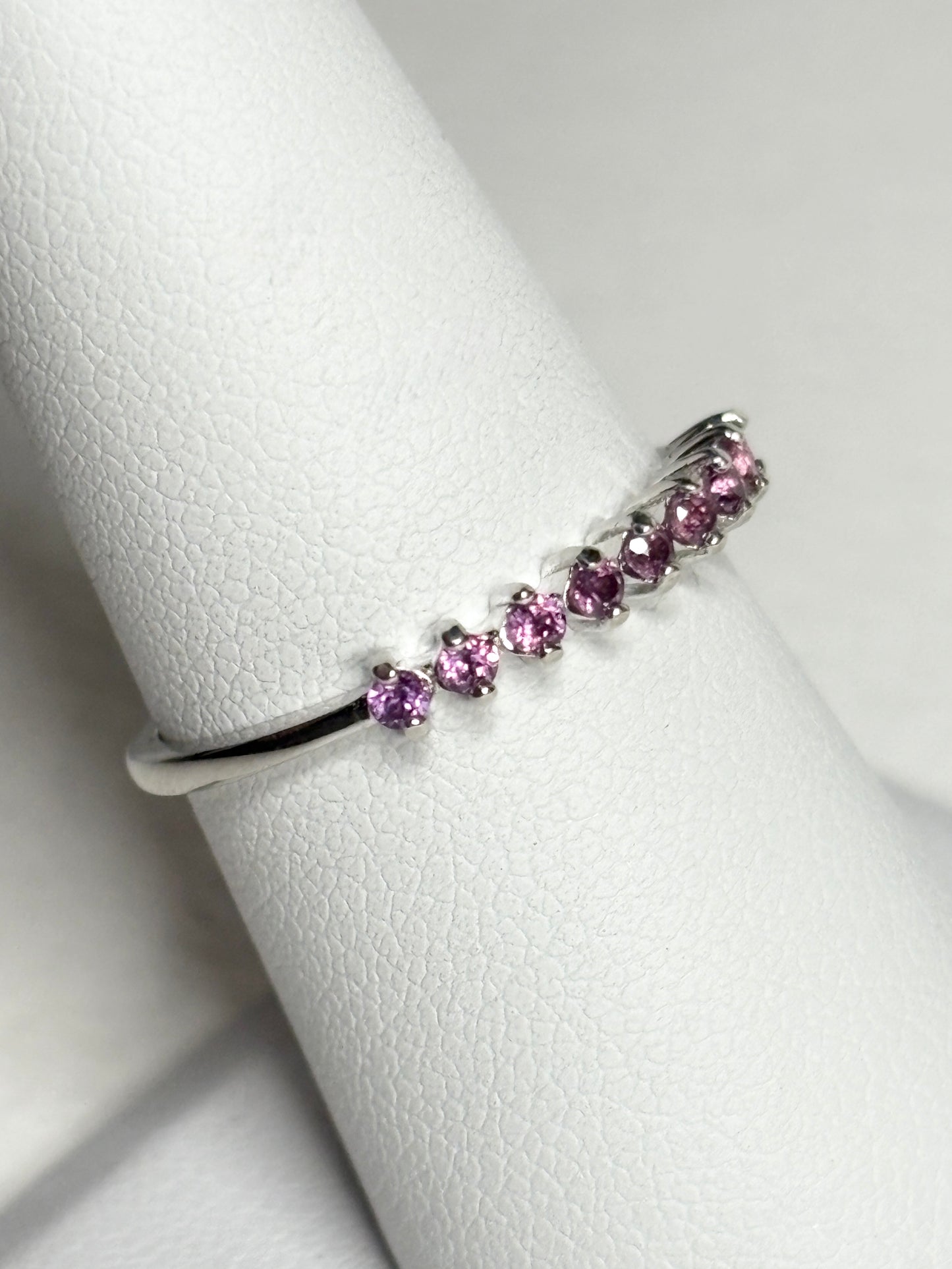Sterling silver band ring with seven small rhodolite garnets.