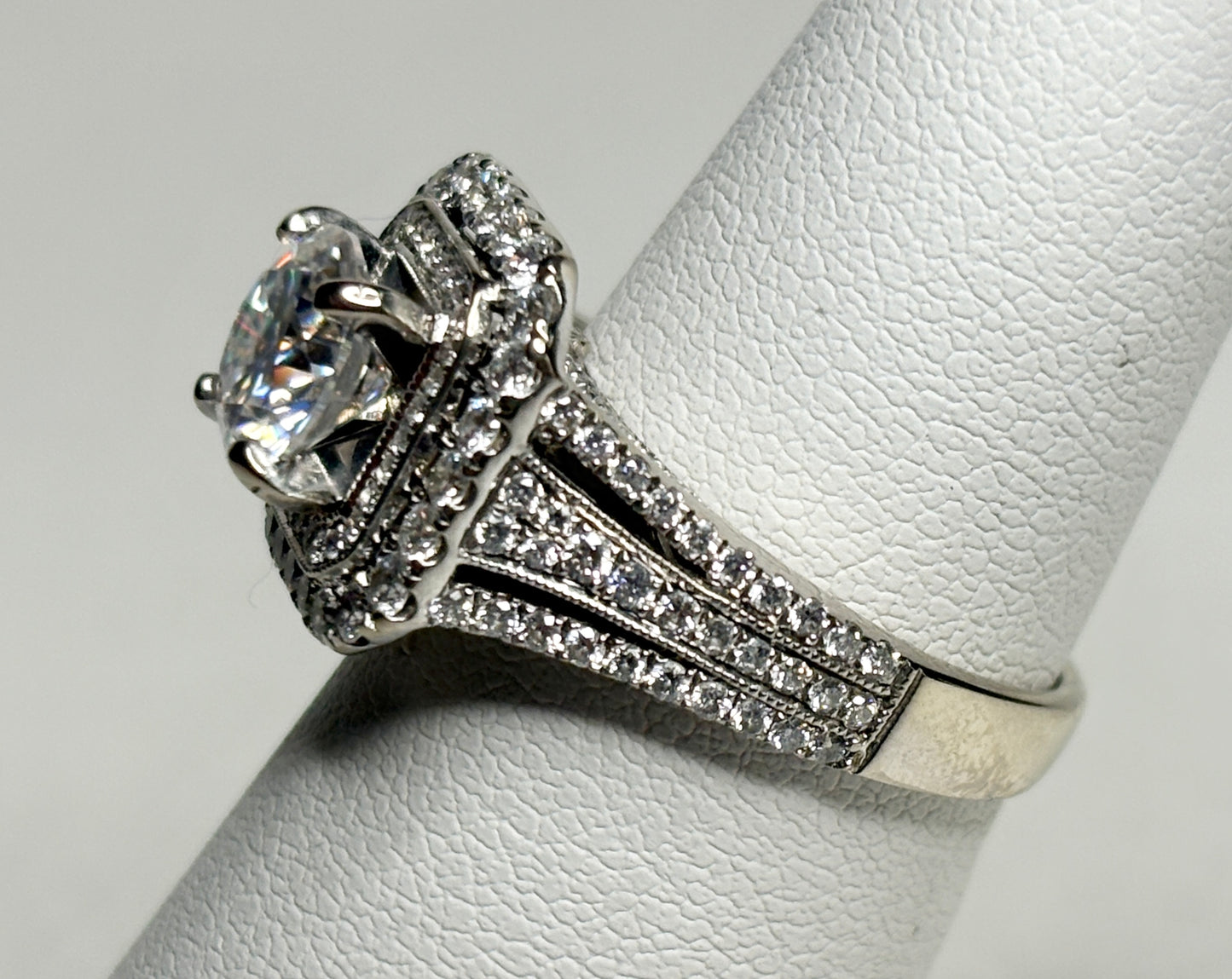 A 14k white gold ring with a large center stone and a double halo of natural diamonds.