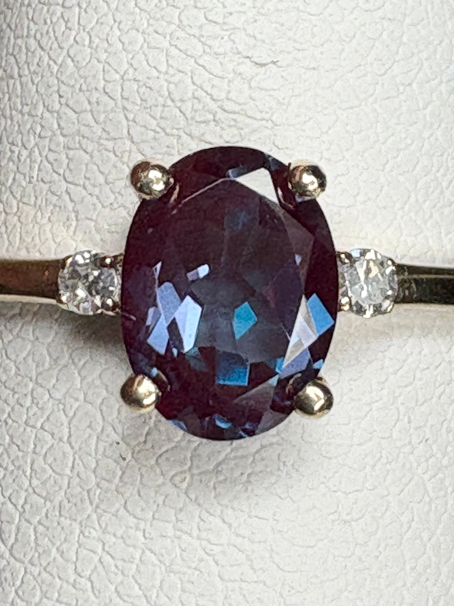 Ring with oval lab-grown alexandrite and diamonds in 10k gold.