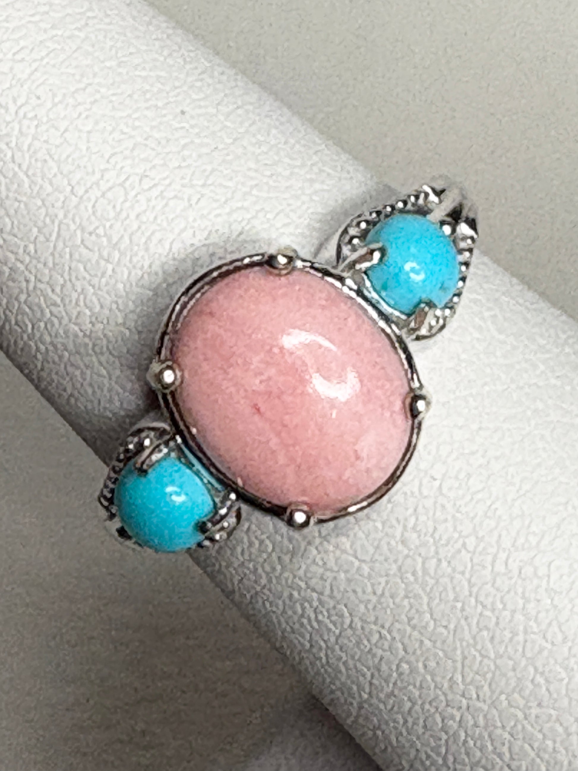 Sterling silver ring with oval peach opal and two round turquoise stones.