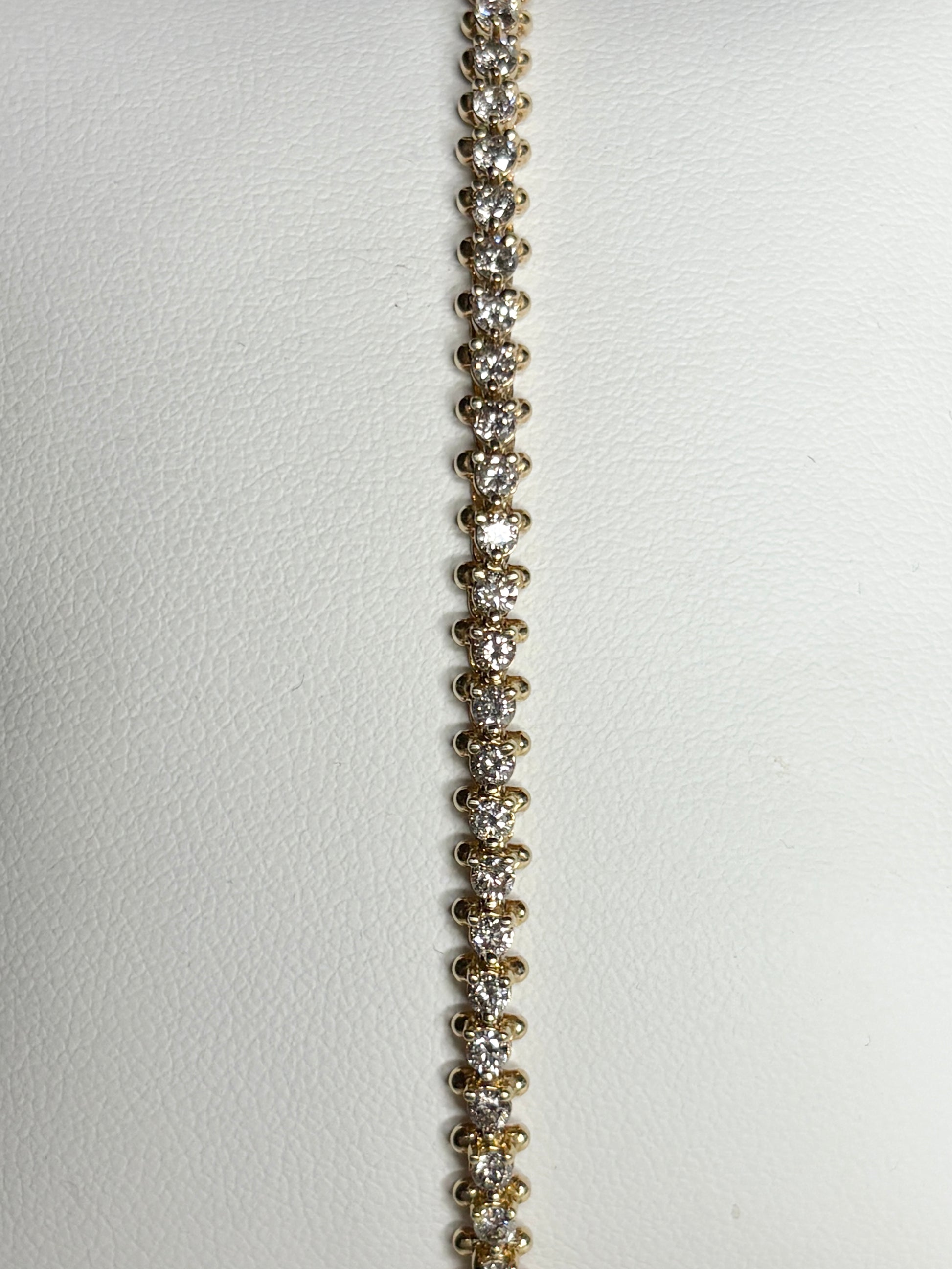 A 14k gold tennis bracelet with 57 round diamonds.