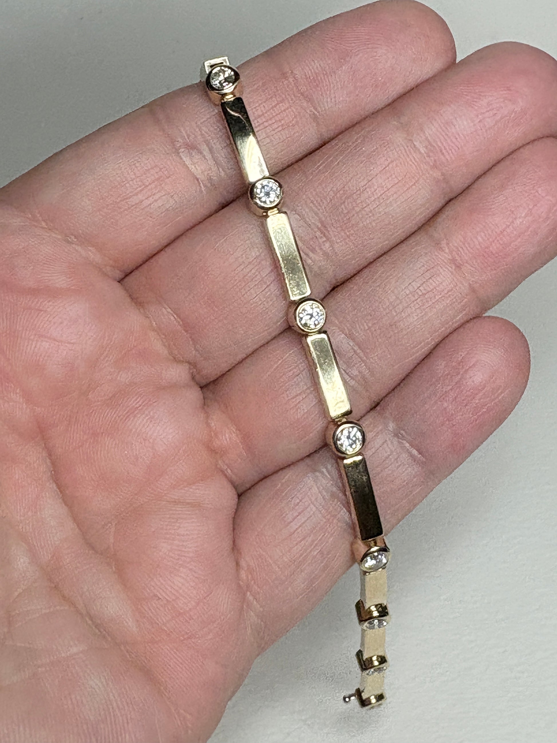14k yellow gold tennis bracelet with 11 bezel-set diamonds.