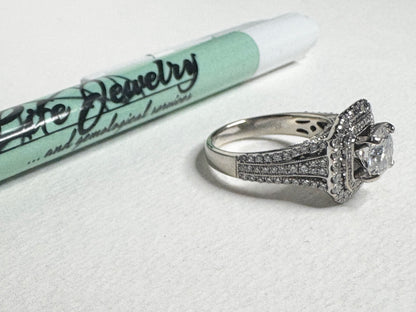 A 14k white gold ring with natural diamonds and a moissanite center stone.