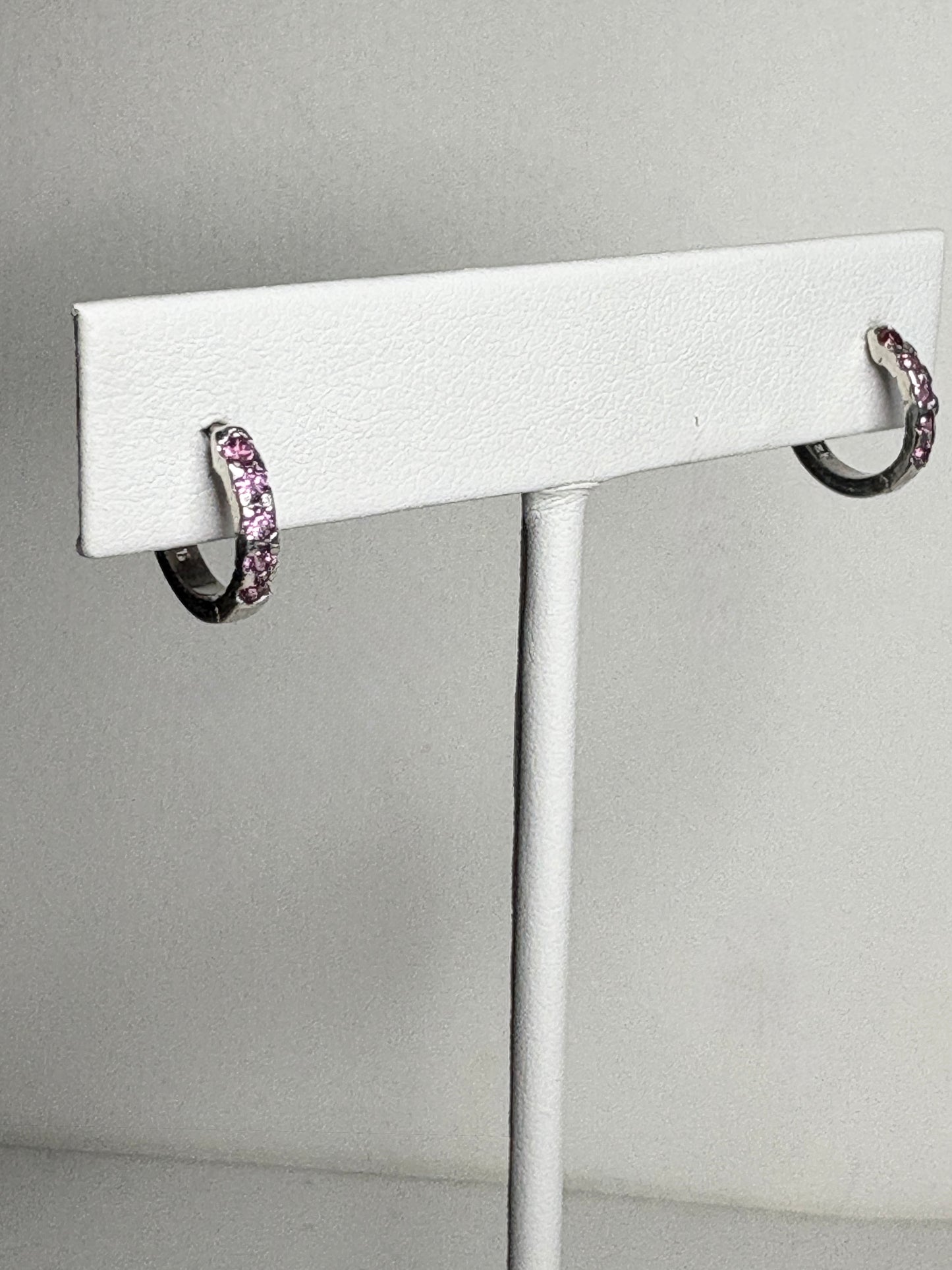 Small sterling silver huggie hoop earrings with rhodolite garnets.