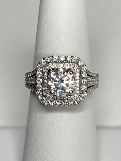 A 14k white gold ring with a central moissanite and a double halo of natural diamonds.