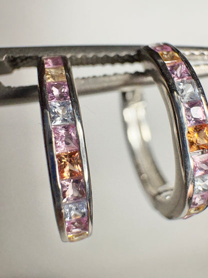 Sterling silver huggie hoop earrings with princess-cut multi-color sapphires.