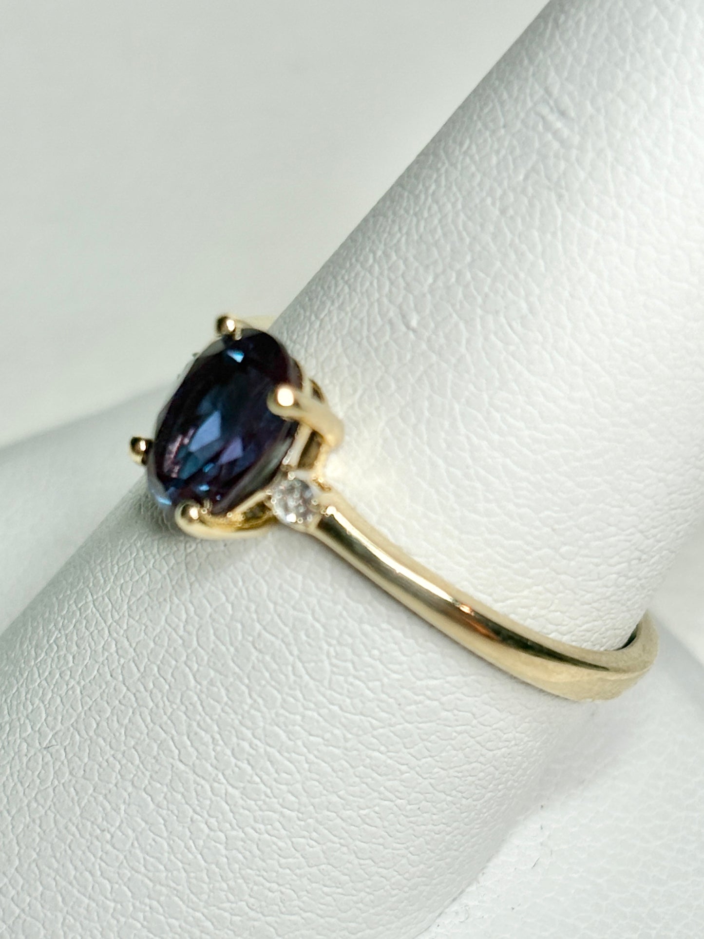 Oval lab-grown alexandrite and diamond ring in 10k gold.