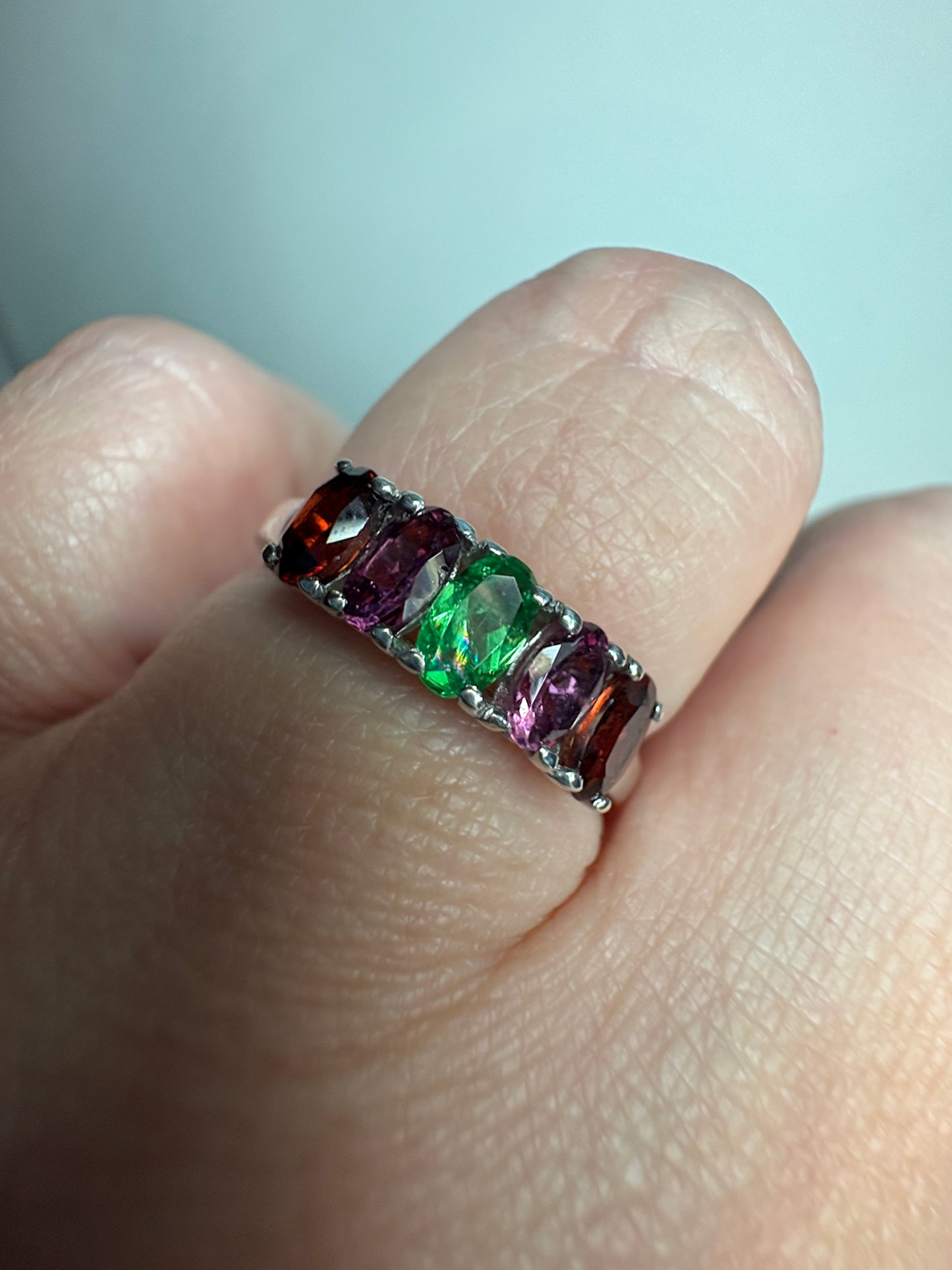 Sterling silver band with oval almandine, rhodolite, and tsavorite garnets.