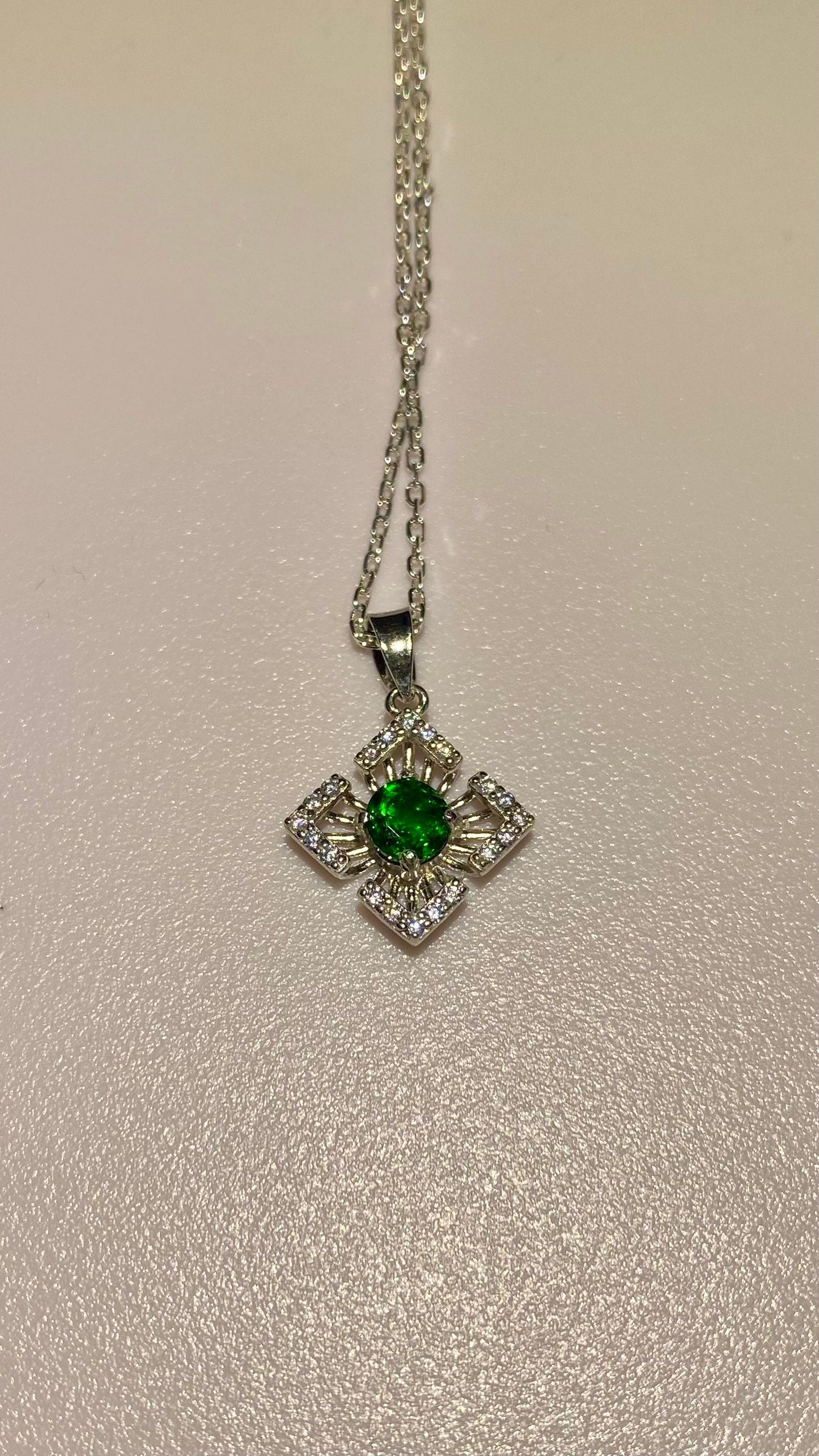 Sterling silver pendant necklace with a green chrome diopside center and clear accents.