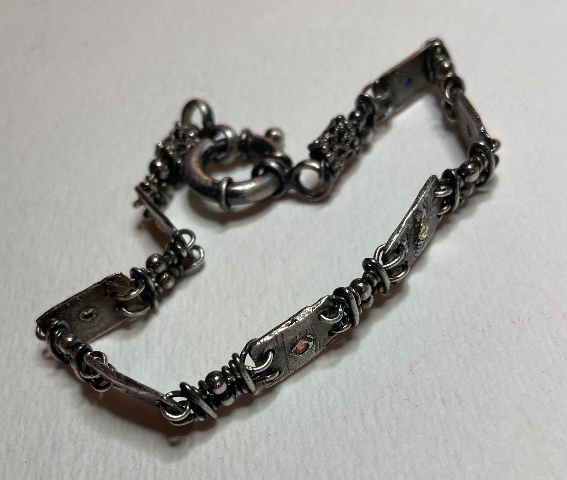 Hand forged sterling silver bracelet with multi-colored sapphire stations.