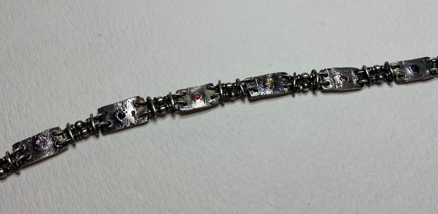 Multi-color sapphire fine PMC silver and sterling hand-forged station bracelet.