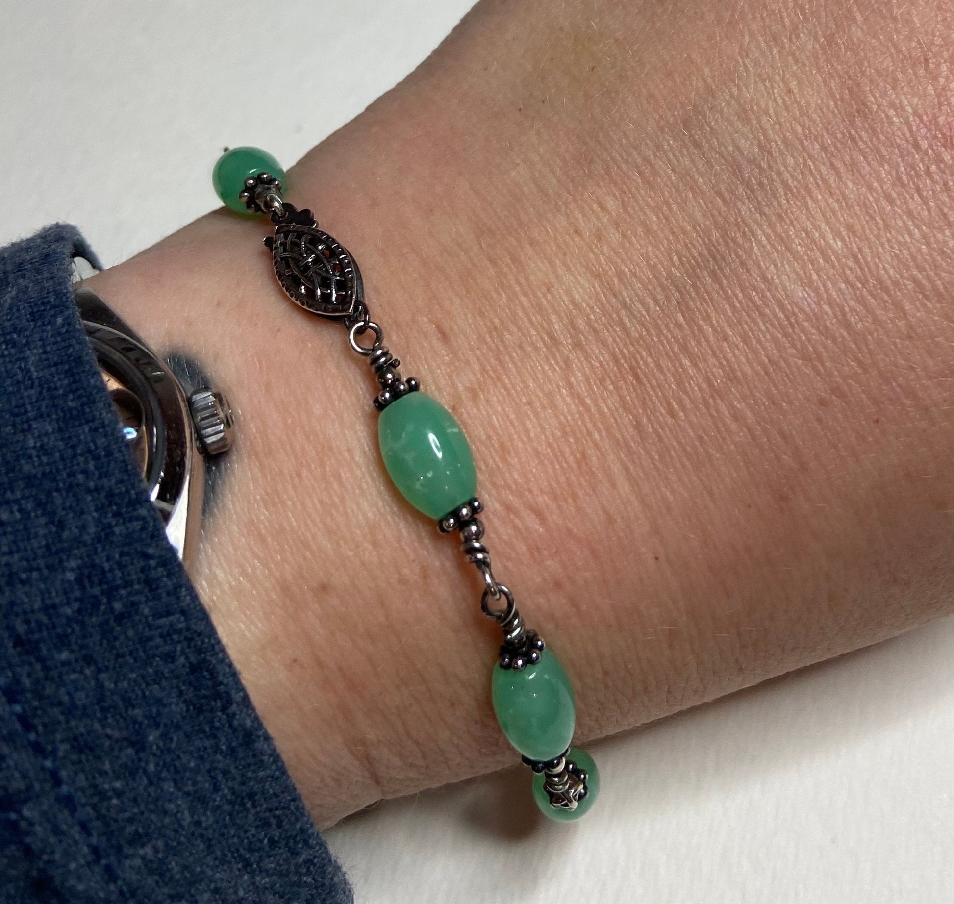 Sterling silver bracelet with oval chrysoprase beads and filigree clasp.