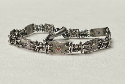 Hand forged sterling silver bracelet with multi-colored sapphires and PMC silver stations.