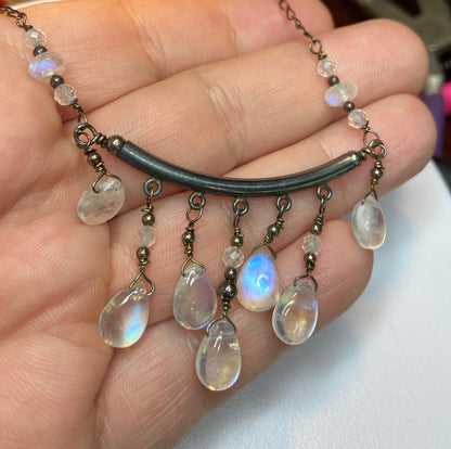 Rainbow blue sheen moonstone sterling silver wire wrapped necklace in black finish.