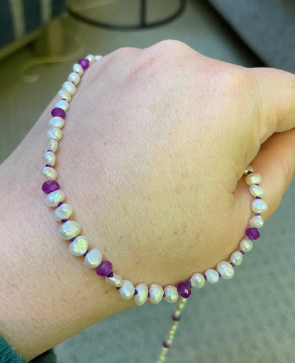 Freshwater oval keshi pearls with purple jade accents on a silk cord.