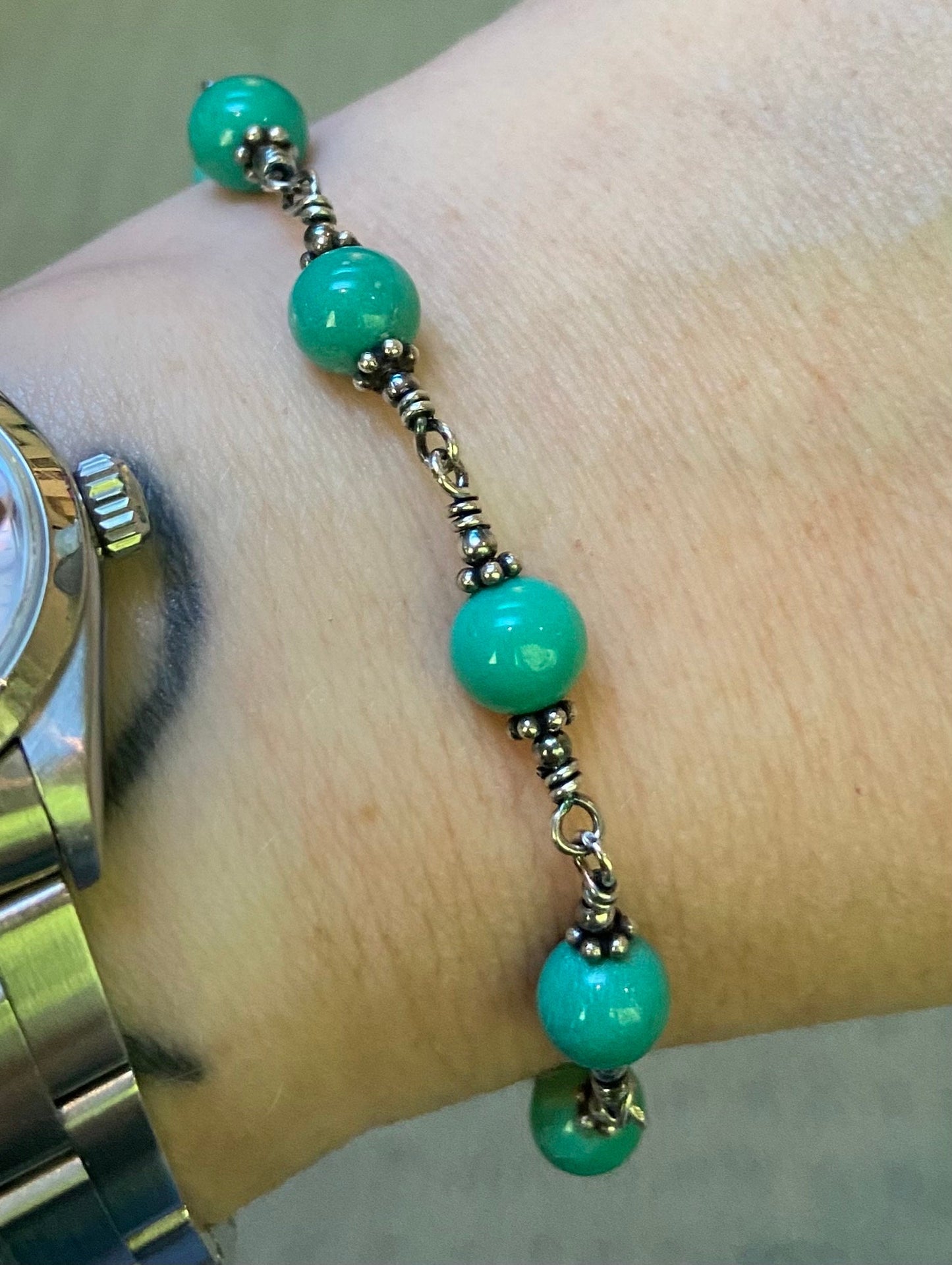 Sterling silver bracelet with blue jasper beads and ornate wire wrapping.
