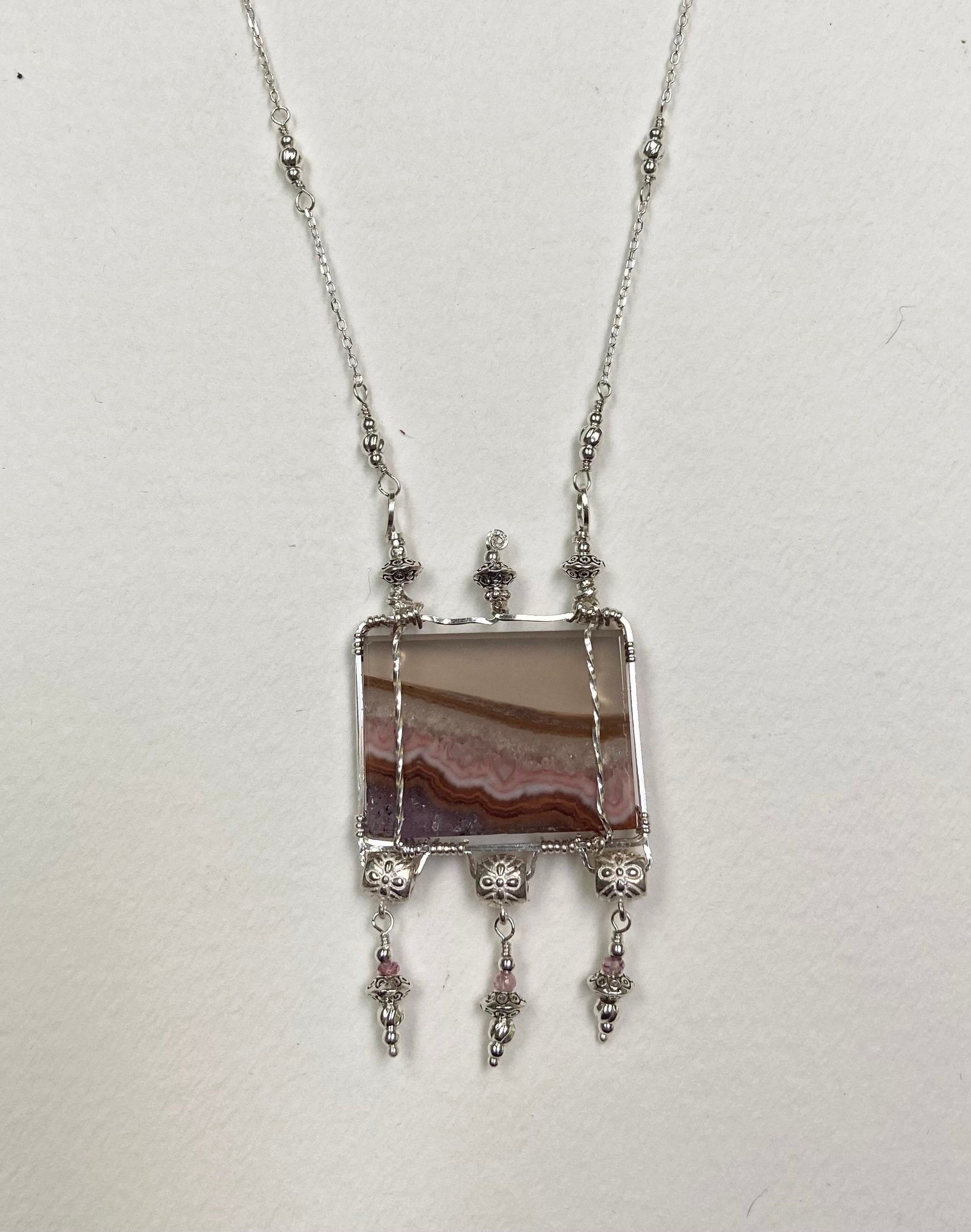 Sterling silver necklace with a rectangular agate and amethyst slice pendant and pink spinel accents.