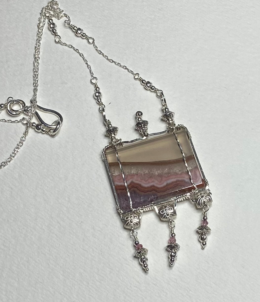 Sterling silver necklace with a rectangular amethyst and agate slice pendant and pink spinel accents.