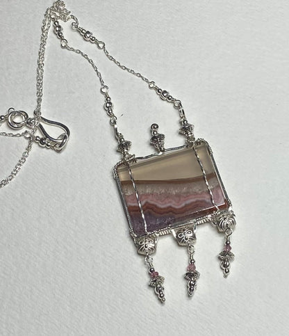 Sterling silver necklace with a rectangular amethyst and agate slice pendant and pink spinel accents.