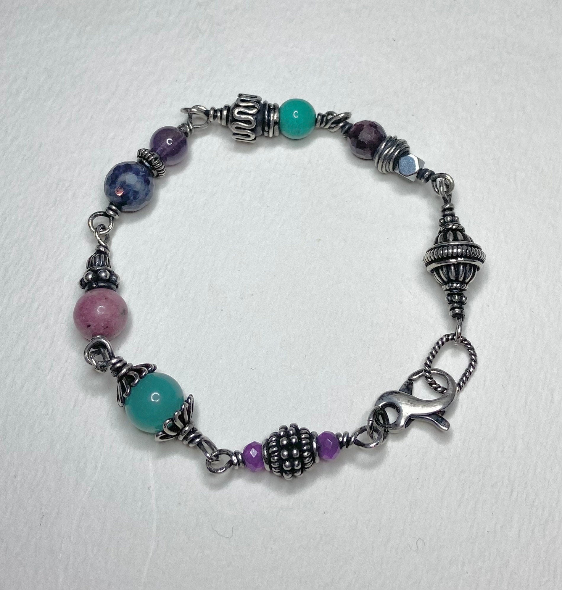 Sterling silver beaded bracelet with multi-colored gemstones and ornate silver accents.