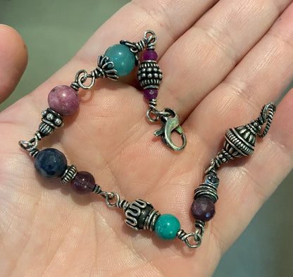Sterling silver beaded bracelet with multi-colored gemstones and a lobster clasp.