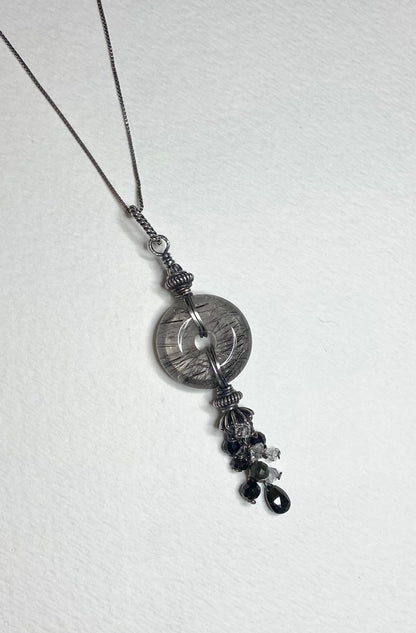 Sterling silver necklace with a tourmalated quartz donut pendant and a tassel of tourmaline and herkimer diamond quartz.