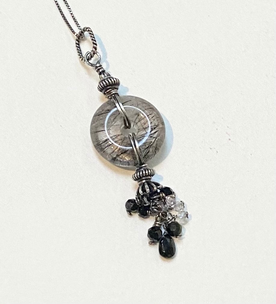 Sterling silver necklace with a tourmilated quartz pendant and a tassel of tourmaline and herkimer diamond quartz.