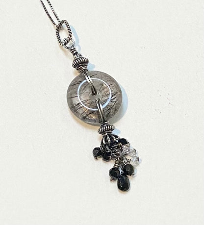 Sterling silver necklace with a tourmilated quartz pendant and a tassel of tourmaline and herkimer diamond quartz.
