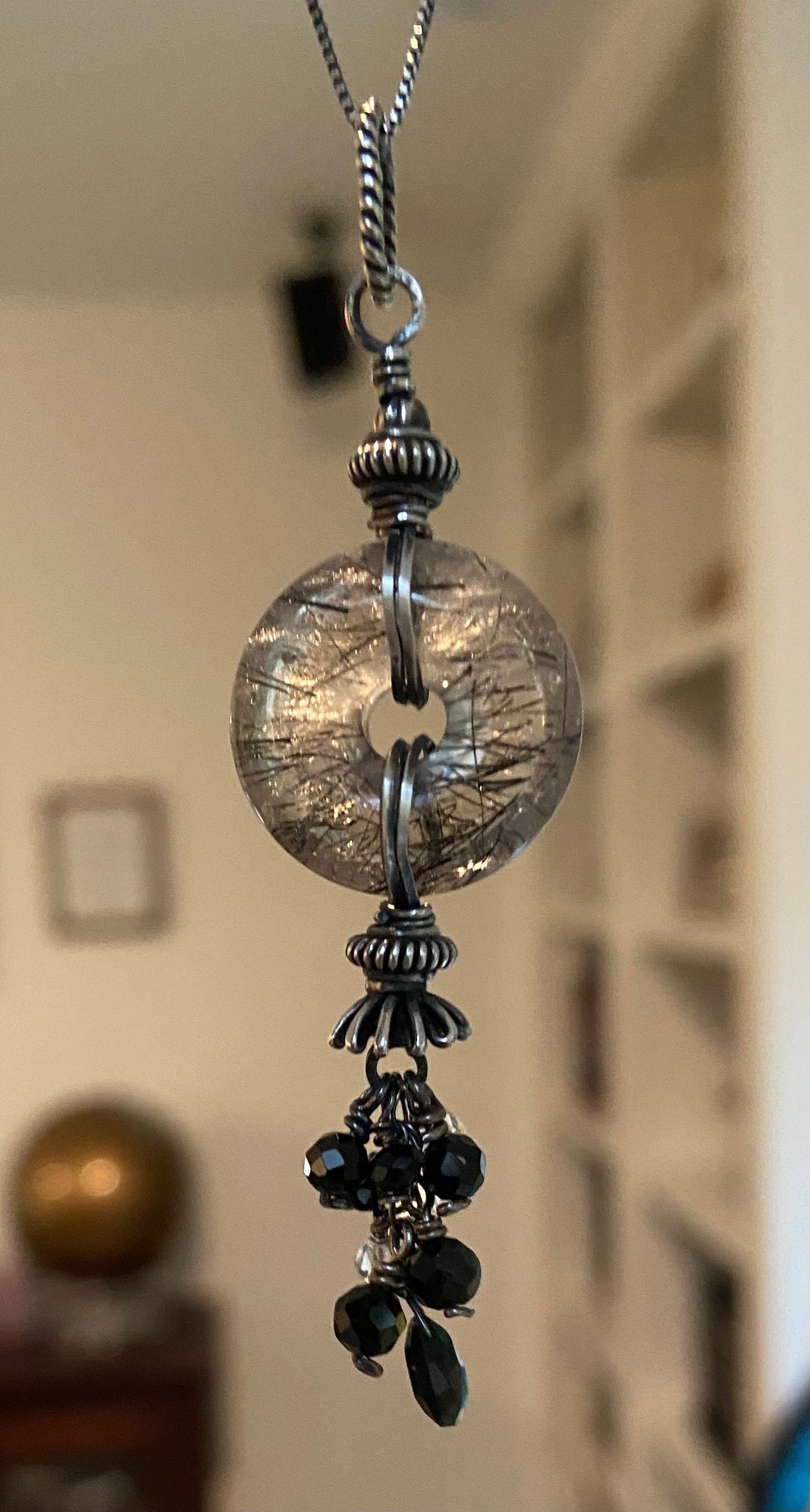 Sterling silver necklace with a tourmalated quartz donut pendant and a tassel of tourmaline and herkimer diamond quartz.