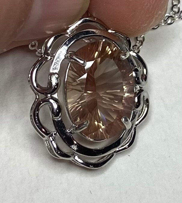 Oval fancy cut Oregon Sunstone in a sterling silver pendant necklace.