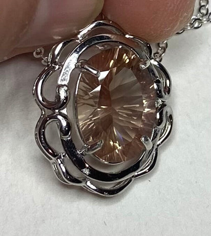 Oval fancy cut Oregon Sunstone in a sterling silver pendant necklace.