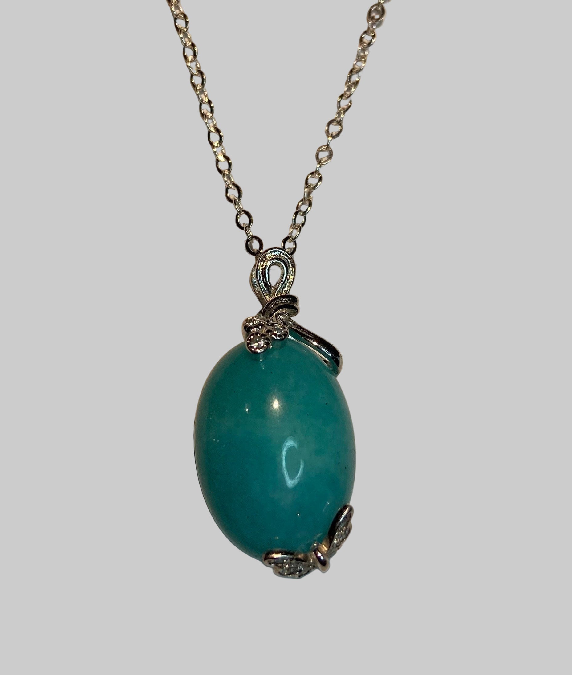 Sterling silver necklace with a Peruvian Amazonite pendant featuring butterfly and floral ribbon details.