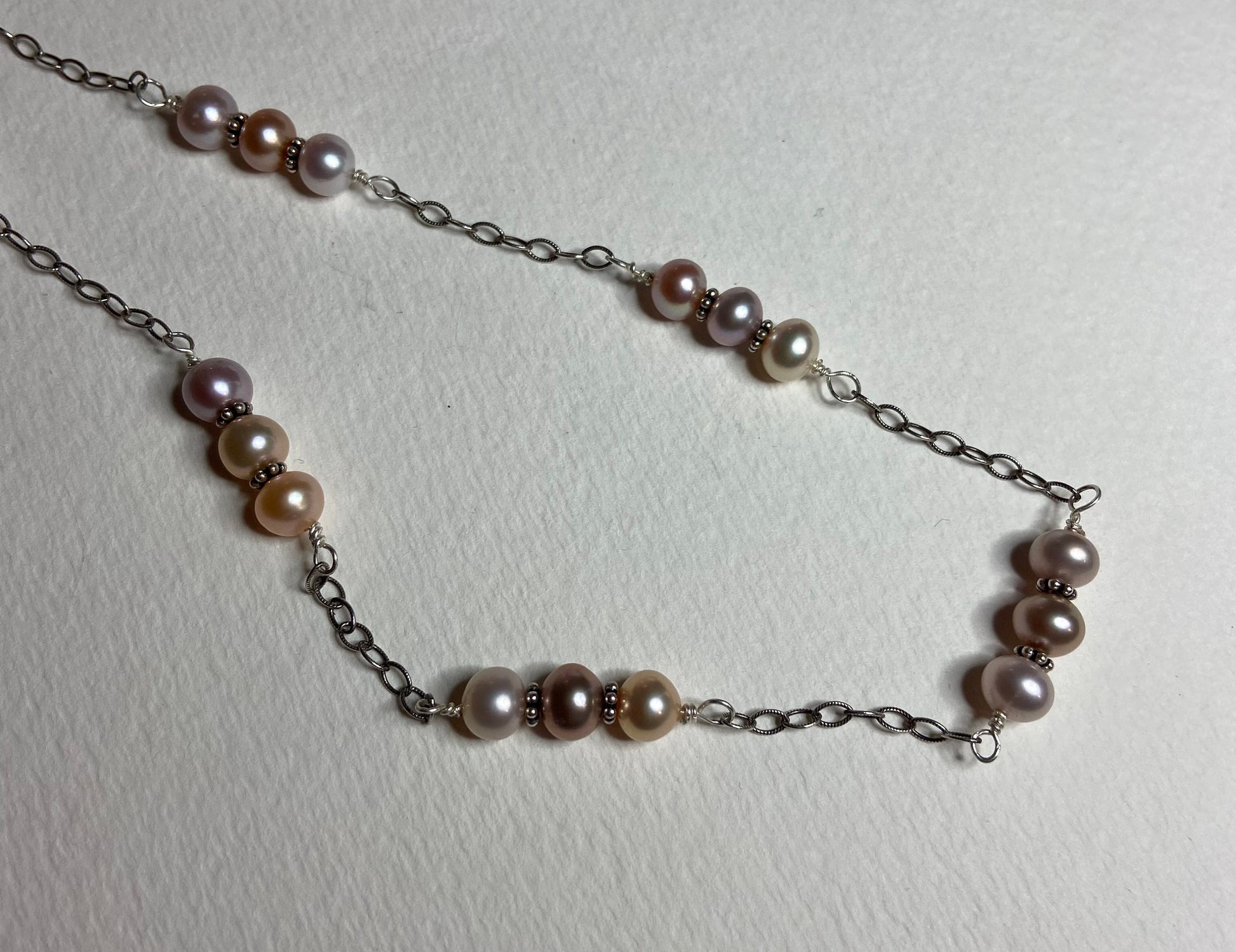 Sterling silver necklace with peach, pink, and lavender freshwater pearls.