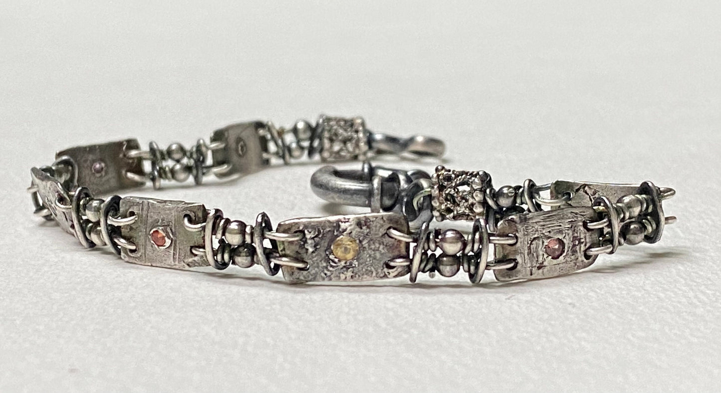 Multi-color sapphire fine PMC silver and sterling hand-forged station bracelet.