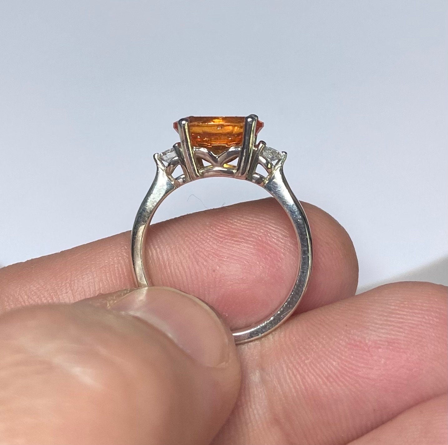 Sterling silver ring with a spessartite garnet and two lab-grown diamonds.