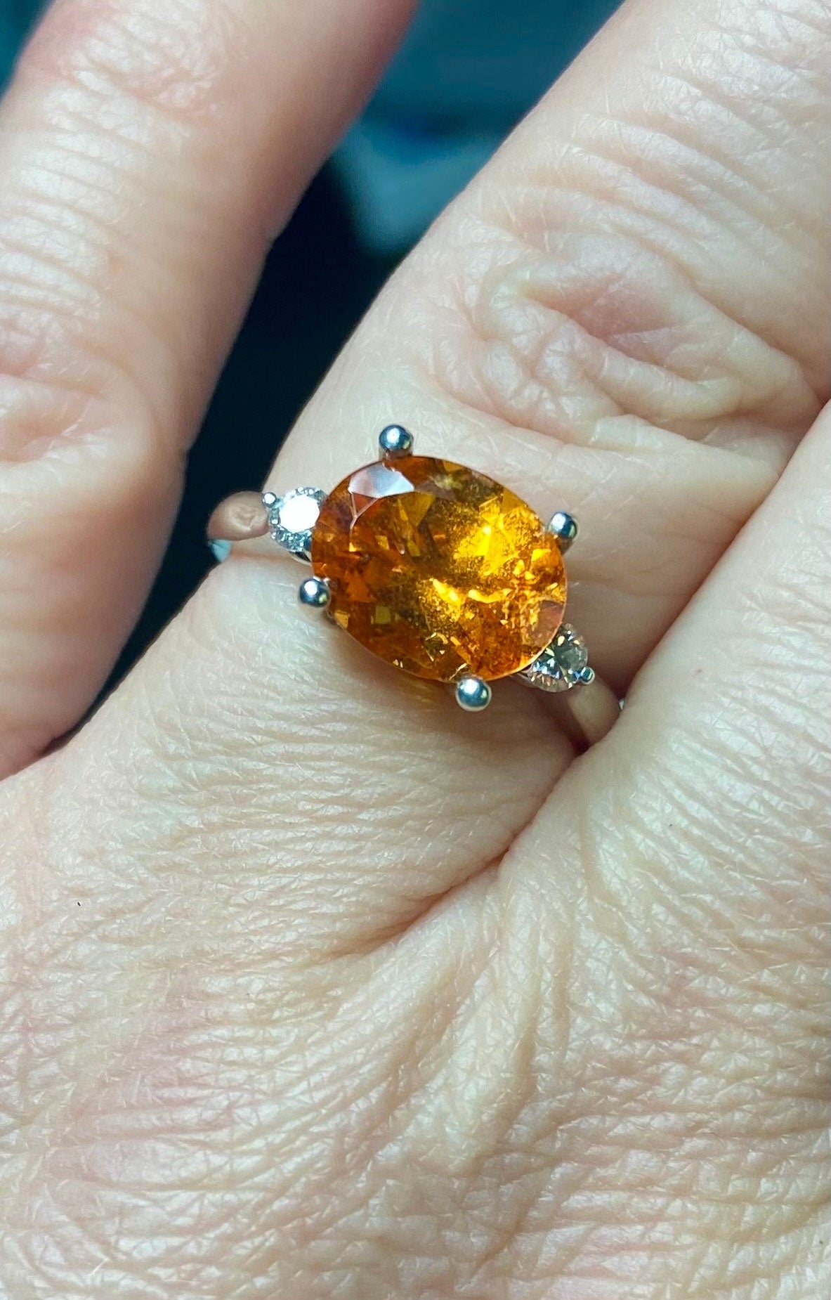Sterling silver ring with oval spessartite garnet and two lab-grown diamonds.