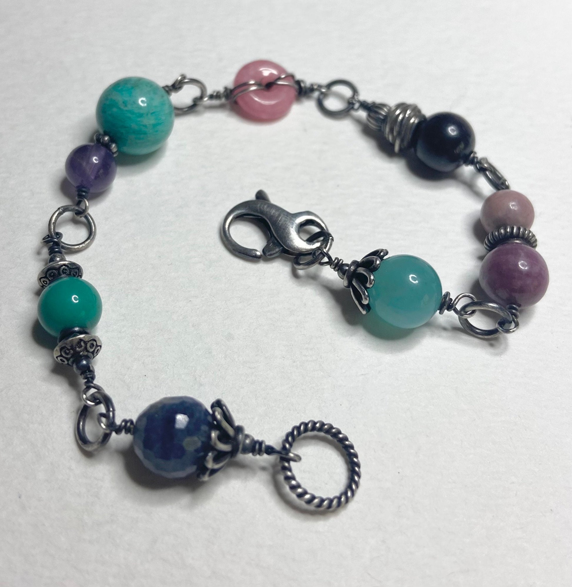 Sterling silver bracelet with multi-colored gemstone beads including star sapphire and amazonite.