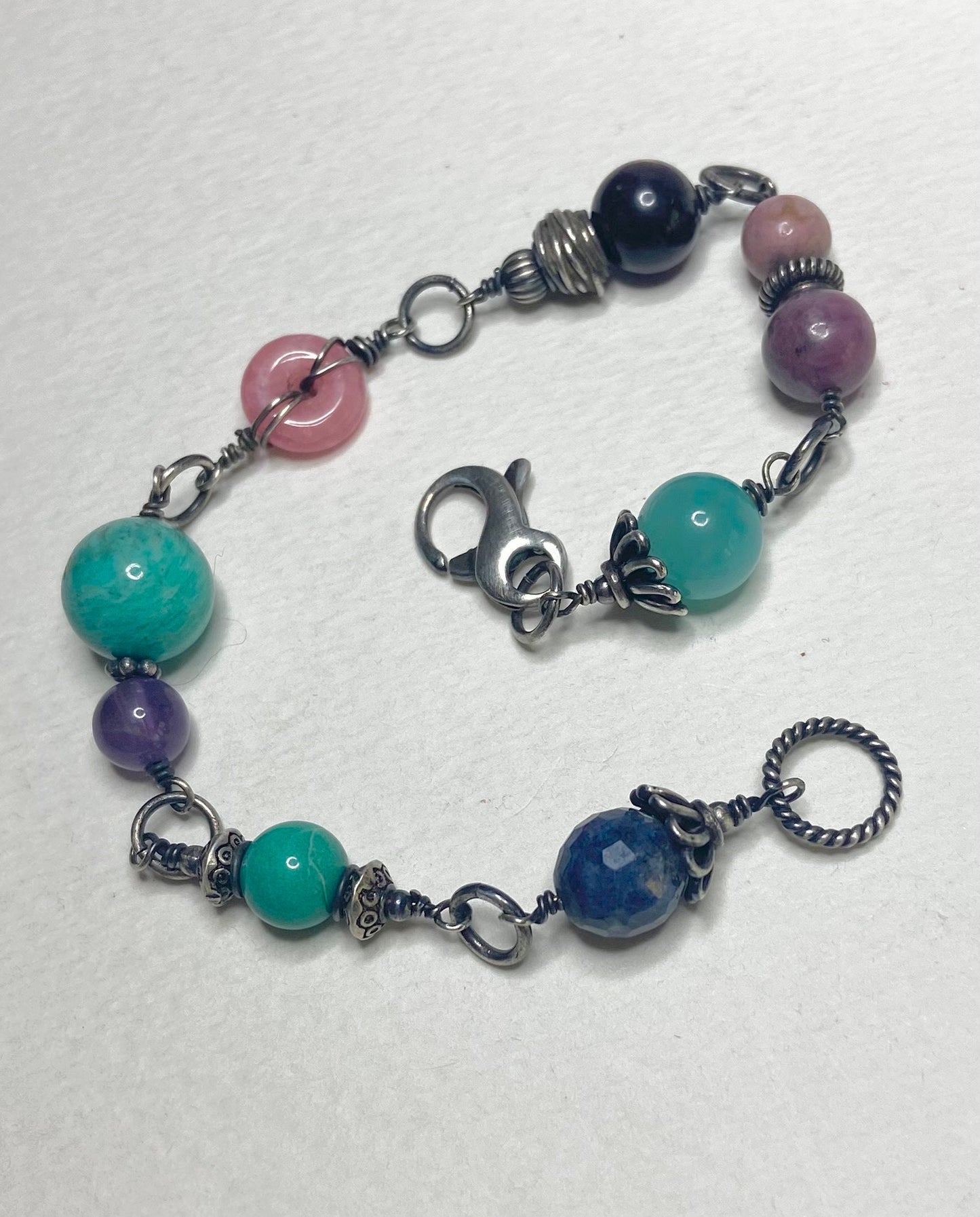 Sterling silver bracelet with multi-colored gemstone beads including star sapphire and amazonite.