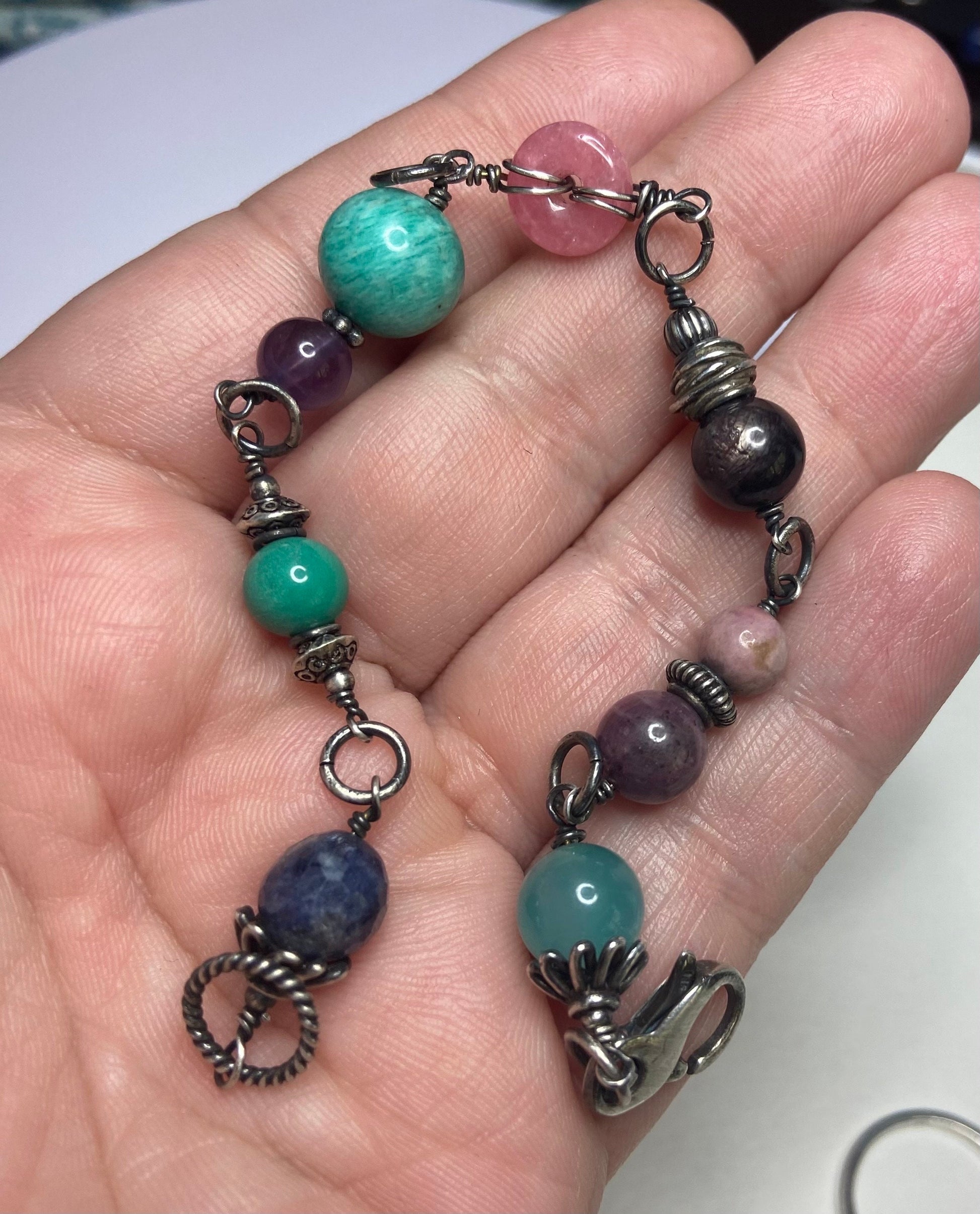 Sterling silver beaded bracelet with star sapphire, amazonite, rhodochrosite, and other gems.