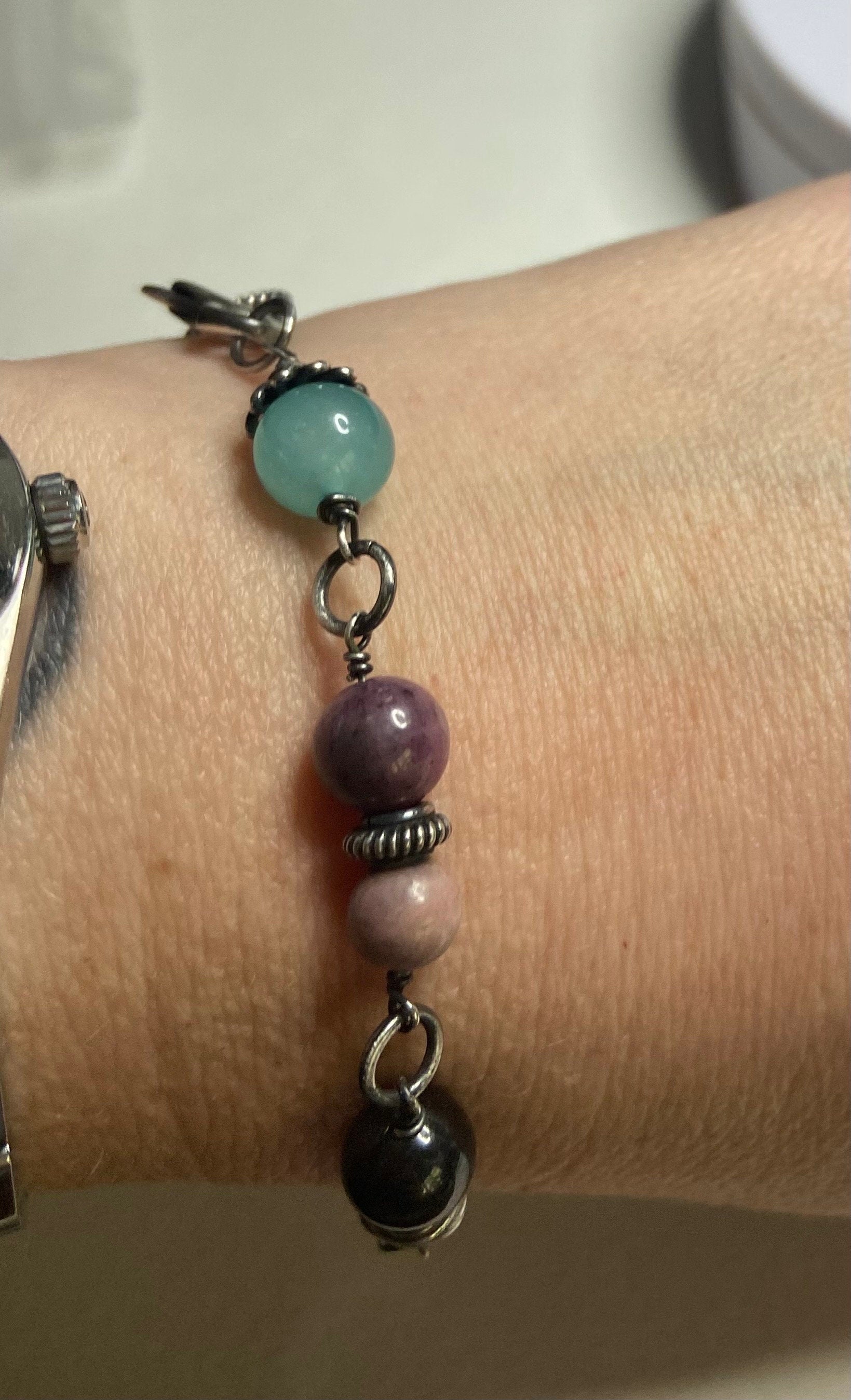 Sterling silver bracelet with star sapphire, amazonite, rhodochrosite, and other gems.