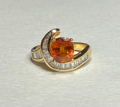 18k yellow gold ring with oval spessartite garnet and baguette diamonds.