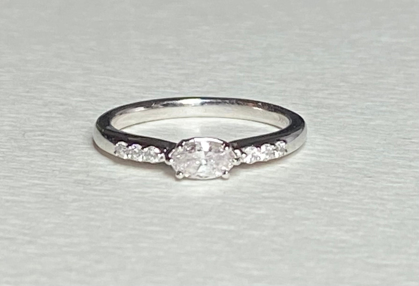 A 14k white gold band ring with a marquise-cut pink diamond and six white accent diamonds.
