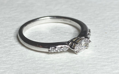 A 14k white gold band ring with a marquise-cut pink diamond and accent diamonds.