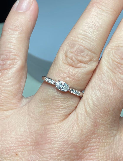 A 14k white gold band ring with a marquise-cut pink diamond and accent diamonds.