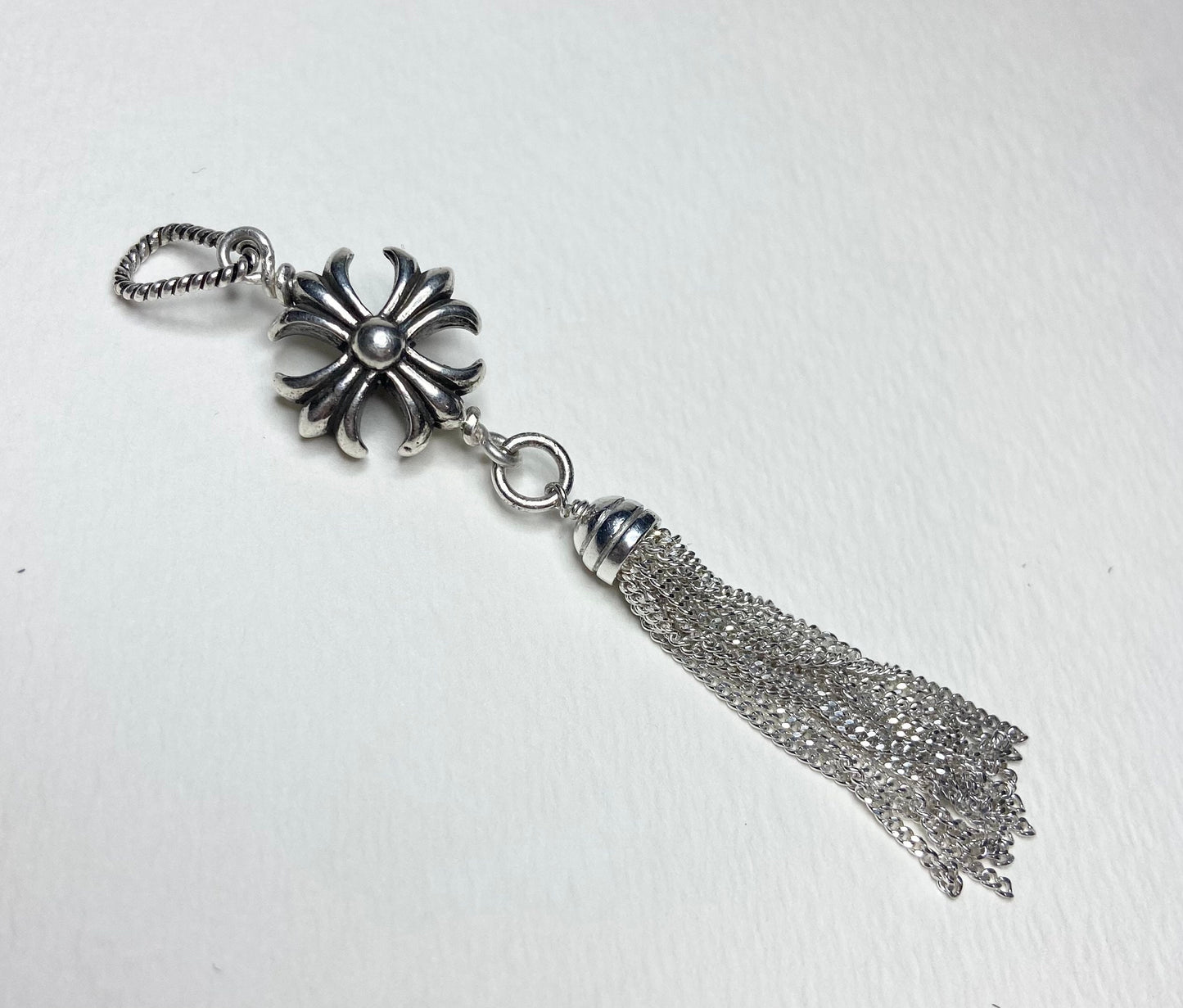 Sterling silver cross tassel pendant with a detailed floral cross and a chain tassel.
