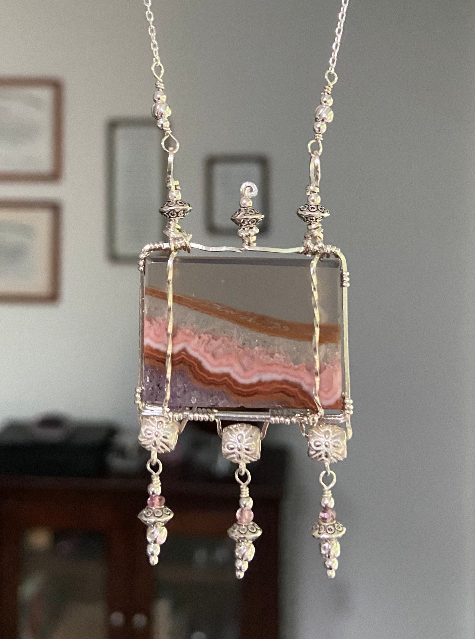 Sterling silver necklace with a rectangular agate and amethyst pendant and pink spinel accents.