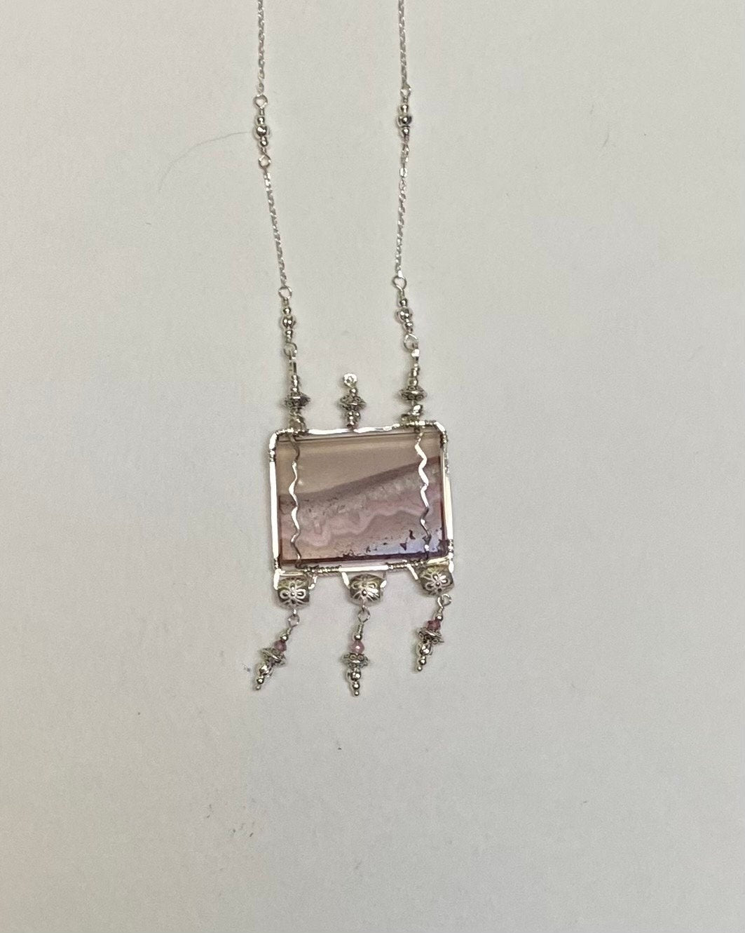 Sterling silver necklace with a rectangular amethyst quartz agate slice and pink spinel dangles.